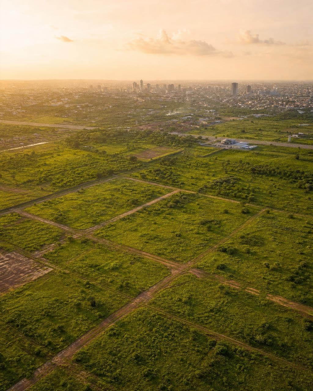 Aerial view of green commercial development land with city skyline in Ghana — land sector.